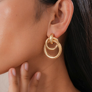 Detailed view of gold interlinked geometric earrings with a distinctive textured finish