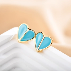 Detailed close-up of sky blue enamel heart earrings with polished gold-tone edges