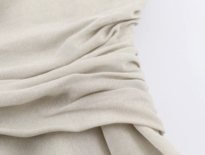 Détail macro du tissu en dentelle georgette beige montrant la texture délicate et douce