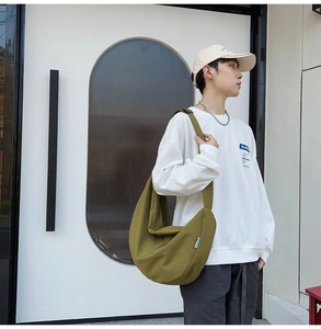 Olive green large capacity crescent crossbody bag in canvas shown on a model street style