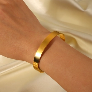 Détail d'un bracelet ouvert en acier inoxydable plaqué or 18K avec zircon sur de la soie