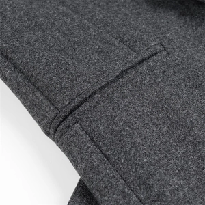 Detailed macro view of dark grey wool fabric texture and stitching on the coat pocket