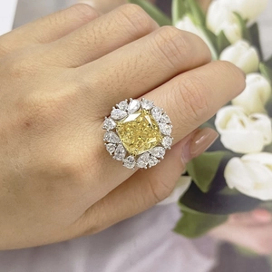 Detailed close-up of a cushion-cut yellow gemstone ring with a marquise diamond halo