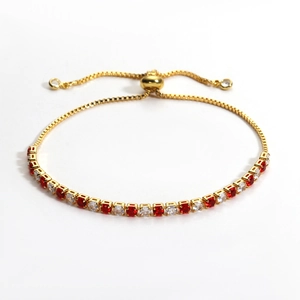 Detail of adjustable gold-plated bolo tennis bracelet with red and white round zircons