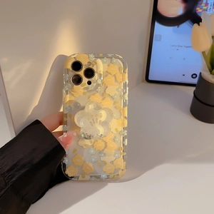 Floral iPhone case detail showing a glitter flower grip stand with yellow and blue blossoms