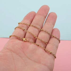 Golden 304 stainless steel bead chain necklace with lobster clasp held on a hand