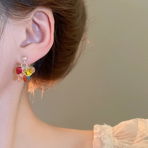 Close-up of model wearing colorful beaded tassel earrings with vibrant acrylic glass stones