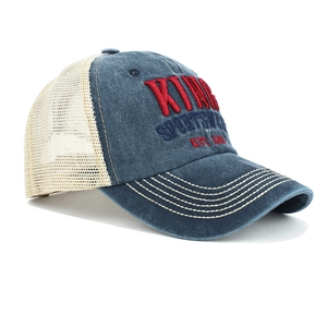 Dettaglio del ricamo 3D KING sul cappellino trucker in denim lavato blu e beige