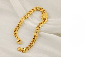 Dettaglio del bracciale a catena cubana dorata con ciondolo centrale a rilievo tondo