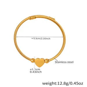 Detailed view of flexible gold stainless steel wire bracelet with smooth heart pendant