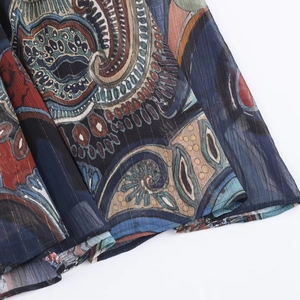 Detail des Paisley-Midikleids mit vertikalen Metallfäden und marineblau-roten Mustern