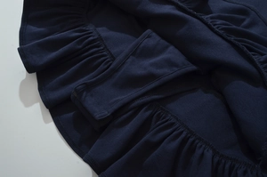 Détail d'une mini-jupe bleu marine avec ourlet à volants et doublure de sécurité intégrée