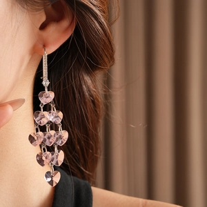 Close-up of pink heart crystal tassel earring with rhinestones on silver metal base