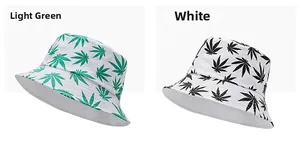Detail view of tie-dye bucket hats with green and black leaf prints on white fabric