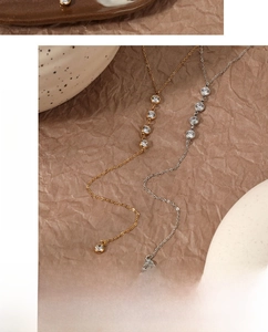 Mise en scène artistique de colliers en Y dorés et argentés avec zircons sur papier
