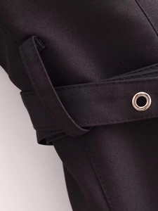 Detailed macro view of black woven fabric texture with silver metal eyelet and waist belt