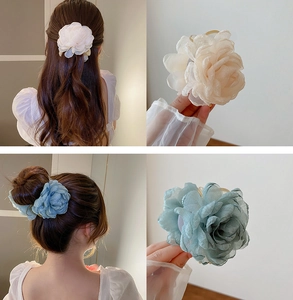 Detail of elegant organza flower hair claws in cream and blue-grey with layered petals