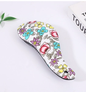 Detail of ergonomic hair brush handle featuring vibrant floral pattern and hanging hole