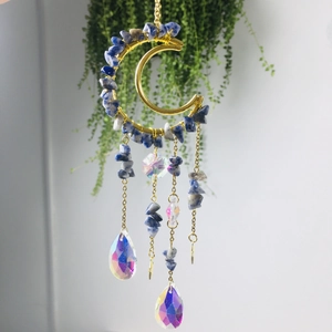 Macro detail of crescent moon suncatcher with amethyst stones and crystal prisms