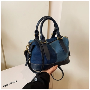 Dettaglio della borsa Boston in patchwork di denim con finiture in pelle blu e metallo oro