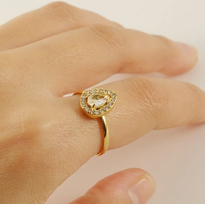 Détail d'une bague goutte en acier inoxydable doré 18K sertie de zircons brillants