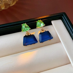 Elegante geometrische Goldohrringe mit grünen und blauen Edelsteinen in einer Box