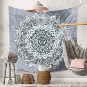 Détail d'une tapisserie mandala blanche sur mur gris foncé dans un salon bohème chic