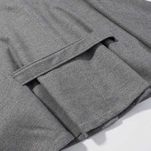 Detailed macro view of dark grey wool jacket fabric with waist loops and precise stitching