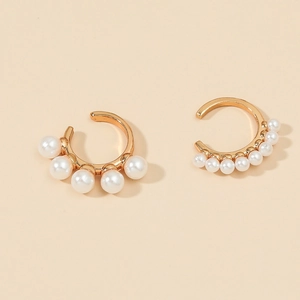 Detail of gold-plated C-shaped ear cuffs set with five white synthetic pearls