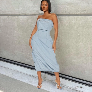 Dettaglio dell'abito a fascia in denim azzurro con tasche cargo utility e zip frontale