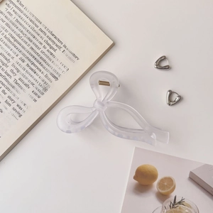 Pince à cheveux nœud mat et boucles d'oreilles cœur argenté sur fond décoratif