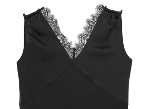 Detail of elegant black V-neck top with delicate eyelash lace trim on silk fabric