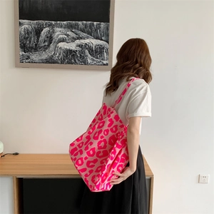 Pink leopard print tote bag shown on model back in a stylish indoor lifestyle setting