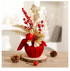 Dettaglio di albero di Natale da tavolo con bacche rosse, foglie d'oro e base in velluto