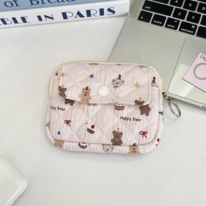 Detail view of a pink quilted cotton pouch with Happy Bear print and metal key ring