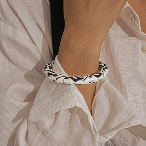 Detail of zebra pattern faux leather open cuff bracelet on a female model wrist