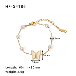 Detail of gold pearl bracelet featuring a white butterfly pendant and 6mm pearls