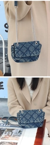 Detailed view of blue denim quilted chain bag with silver woven metal strap