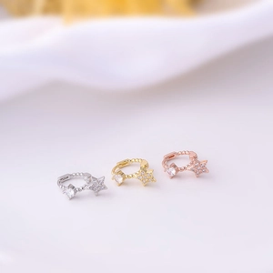 Macro detail of geometric hoop earrings in gold and silver with micro-set zircon accents