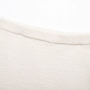 Nahaufnahme von beige Tweed-Strickgewebe mit weichen Fransen und Webstruktur