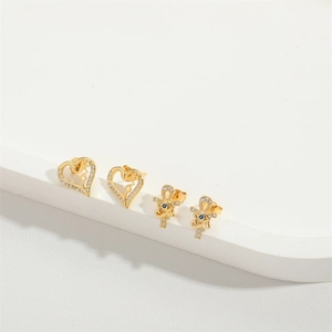 Exquisite gold heart earrings and blue evil eye studs with crystals on display