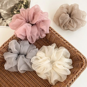 Macro detail of elegant tulle scrunchies in pastel colors arranged in a rustic wicker basket