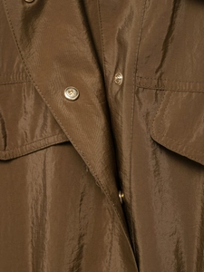 Détail d'une chemise safari bronze avec reflets métalliques et boutons-pression dorés