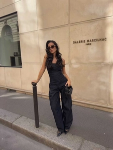 Vista street style di un completo moda in denim nero con top a corsetto e pantaloni