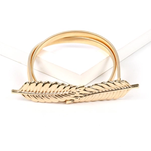 Close-up of golden metal leaf buckle and elastic spring chain belt on white background