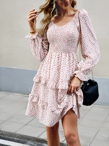 Detail of red floral dress featuring smocked waist design and layered ruffle hemline