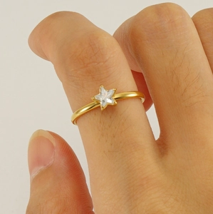 Close-up of a gold stainless steel ring featuring a sparkling star-shaped zircon stone