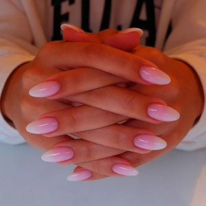Macro view of long almond ombre press-on nails with a high-gloss polished pink finish