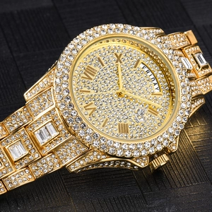 Macro shot of gold business watch with full diamonds and double calendar window display