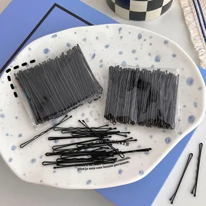 Set of 100 black wave-shaped hair clips in a ceramic dish for hairstyling